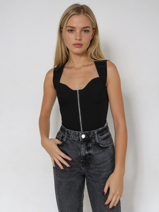 Model wearing black corset with silver front zipper and washed out black mom jeans.