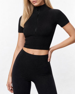 Black ribbed activewear crop top for women featuring a half-zip mock neck, compression fit, and seamless stretch construction for workouts and everyday wear