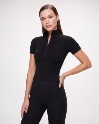 Women’s black ribbed short sleeve zip-up crop top with mock neckline, styled with high-waisted leggings for athleisure, travel, errands and elevated everyday wear.