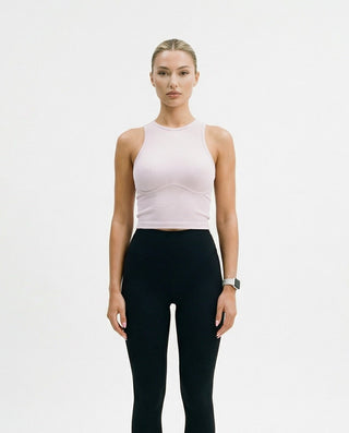 Women’s fitted ribbed crop top with a high neckline and subtle bust contouring, styled on a model against a white studio background.