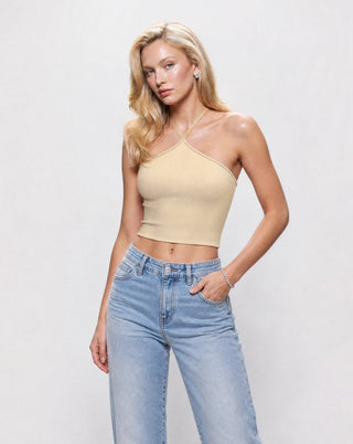 Women’s butter yellow ribbed halter crop top with crisscross neckline, fitted silhouette, and cropped hem styled with light wash wide leg jeans