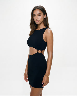 Model wearing a black ribbed mini dress with a sleeveless high neckline, side cutout detail, and circular ring accent, designed with a fitted body-con silhouette against a white background.
