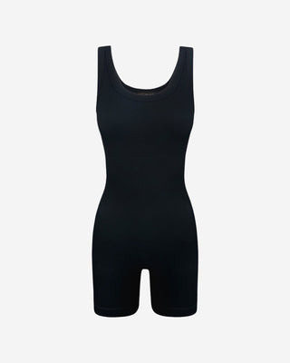 Black ribbed sleeveless romper with scoop neckline and fitted biker shorts, a minimalist women’s one-piece for layering, travel, athleisure, lounging and everyday wear.