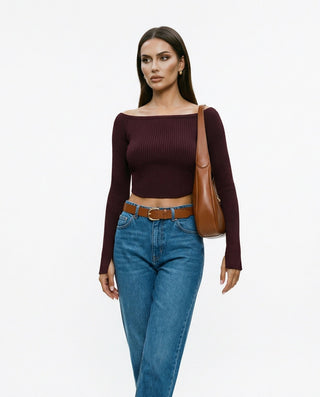 Model wearing maroon colored long sleeve boatneck top with blue jeans and brown accessories.