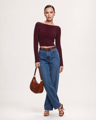 Women's burgundy ribbed off the shoulder crop top with long sleeves, fitted stretch knit fabric, and a chic casual outfit paired with high waisted blue jeans