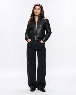 Women's black faux leather puffer jacket with a high stand collar, front zip closure, and cropped silhouette styled with wide leg black jeans