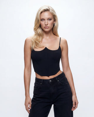 Women’s black fitted corset crop top with sweetheart neckline and structured bustier silhouette paired with high-waisted black denim jeans in a studio setting