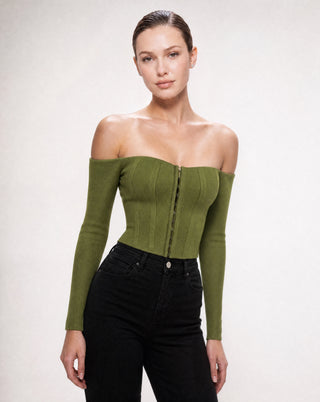 Women's olive green long sleeve off-the-shoulder corset top with a structured fit and front hook closure styled with black high-waisted jeans