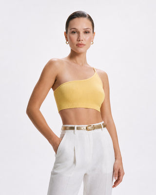 Women’s yellow asymmetrical one shoulder brami crop top with seamless ribbed fit, styled with white pants for brunch, travel, summer vacation and elevated casual wear.