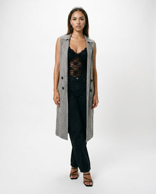 Women’s long gray sleeveless duster vest styled with black lace bodysuit, black jeans and strappy heels for chic fall outfits, date nights and elevated city style.