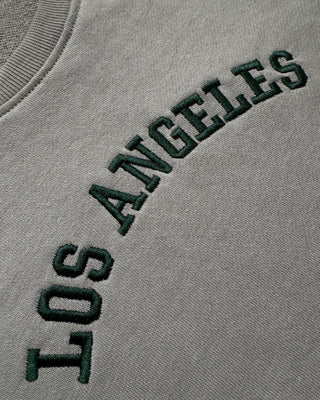 Detailed close-up of Los Angeles embroidery on a vintage wash grey sweatshirt featuring premium raised stitching, collegiate-inspired lettering, and textured threadwork