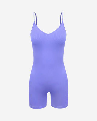 Lavender seamless ribbed cami romper with V-neckline, spaghetti straps and fitted biker shorts, a versatile women’s one-piece for athleisure, travel and casual summer wear.