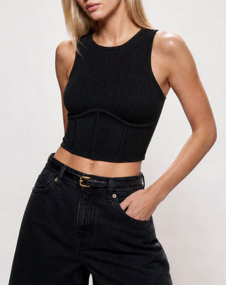 Women's black ribbed sleeveless crop top with corset-inspired seam details, high neckline, and sculpting fit, paired with black denim shorts for a modern casual look