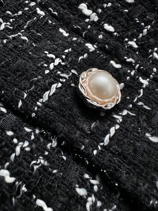 Up close fabric of the Lorin Plaid Mini Skirt's pearl detail button.