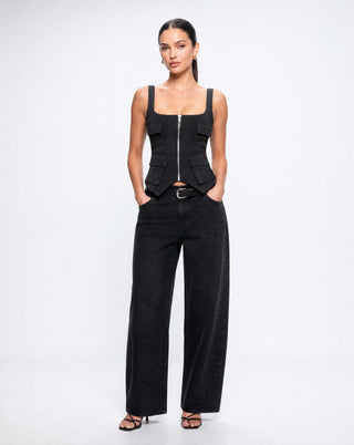Women's black structured utility crop top with a square neckline, exposed front zipper, and cargo pocket accents paired with wide leg denim for a modern street style look