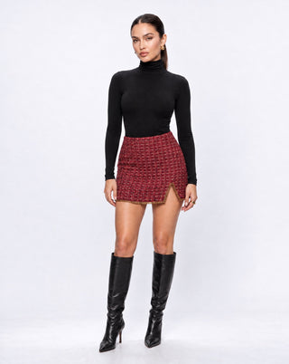 Front view of women’s burgundy red tweed mini skirt featuring a high waist, gold chain trim and side slit, styled for elevated fall fashion, dinner dates, holiday events and going-out looks.