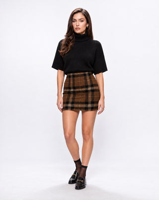 Women’s brown plaid mini skirt styled with a black short sleeve turtleneck, sheer socks and loafers for preppy fall outfits, city days, brunch and elevated everyday style.