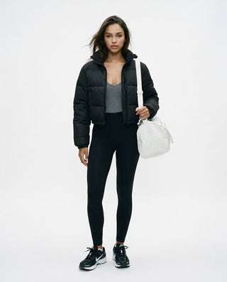 Women’s cropped puffer jacket styled on a model worn open, highlighting the quilted construction, high collar, and cropped silhouette.