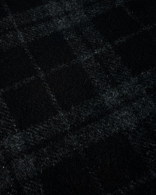 Close view of the skirt’s woven plaid fabric showing a soft brushed texture with intersecting charcoal and gray lines.