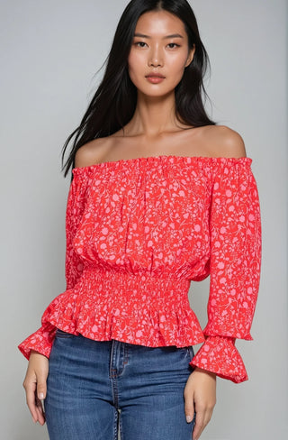 Red and pink chiffon smocked crop top paired with blue jeans.