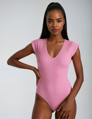 Model wearing a pink ribbed swimsuit against a plain background
