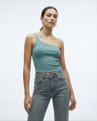 Model styled in a seafoam ribbed one-shoulder crop top with a double strap detail, paired with high-waisted gray denim.