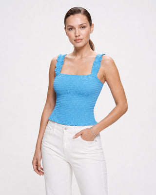 Women’s bright blue smocked tank top with square neckline and ruffle straps, styled with white jeans for summer brunch, vacation and casual daytime outfits.