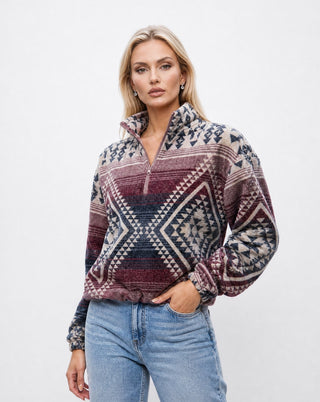 Women’s oversized tribal print fleece pullover in burgundy and cream with quarter zip collar, featuring geometric southwestern pattern and relaxed fit, styled with denim jeans in a clean studio setting.