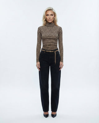 Blonde model wearing Leopard skin full length ruched mock neck top with black jeans and a gold chain belt.