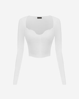 Front view of a white cropped long sleeve top featuring a contoured bust seam design, soft ribbed fabric, and a curved sweetheart neckline.